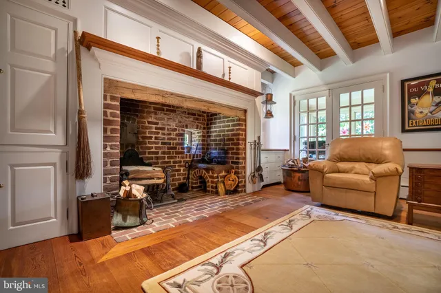 a living room with furniture a fireplace and floor to ceiling window
