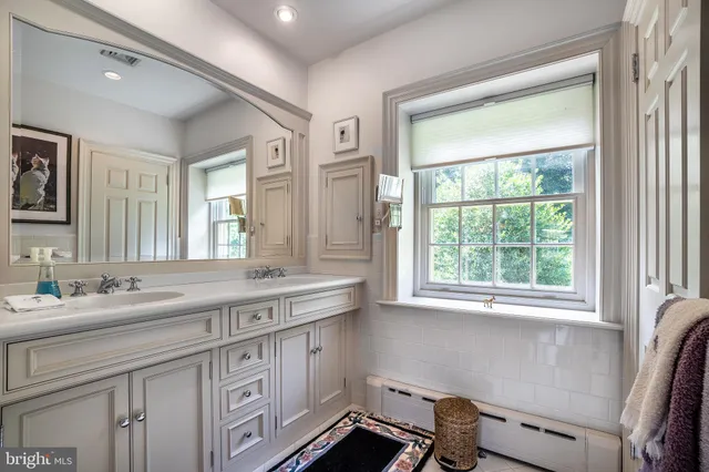 a spacious bathroom with a granite countertop sink and a mirror