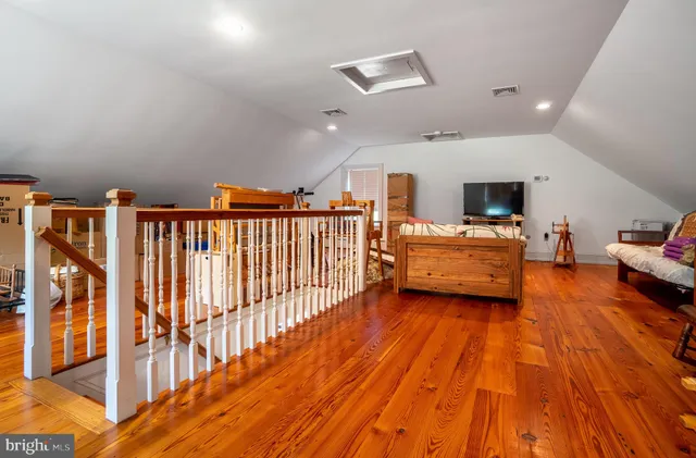 a view of a bedroom with furniture wooden floor and windows