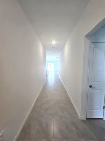 a view of a kitchen with kitchen island a sink wooden floor and stainless steel appliances
