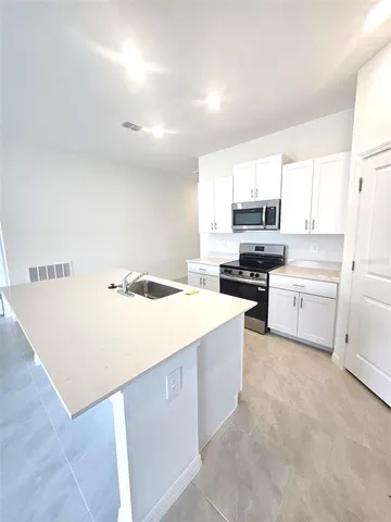 a kitchen with a stove a sink and a refrigerator