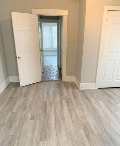 an empty room with wooden floor and entrance