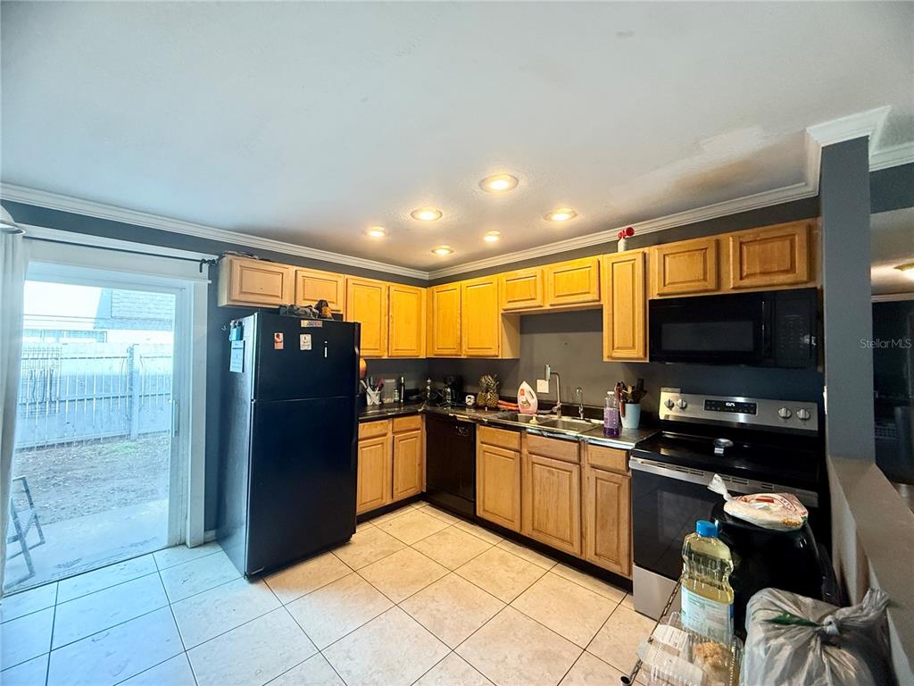 1944 South Conway Road, Unit 3 Orlando, FL 32812 - Photo 5 of 20 a kitchen with granite countertop a refrigerator and a stove top oven