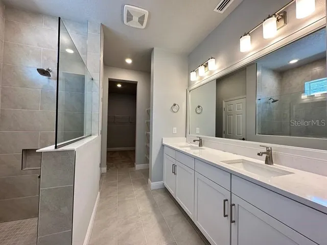 a bathroom with a double vanity sink and a mirror