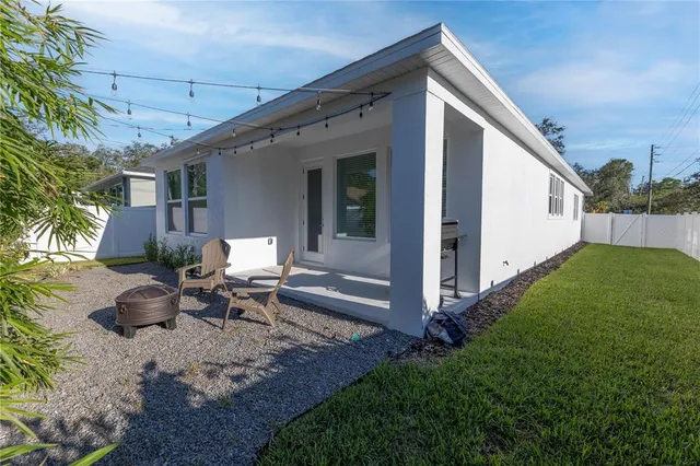 a view of a patio with table and chairs with wooden fence and plants