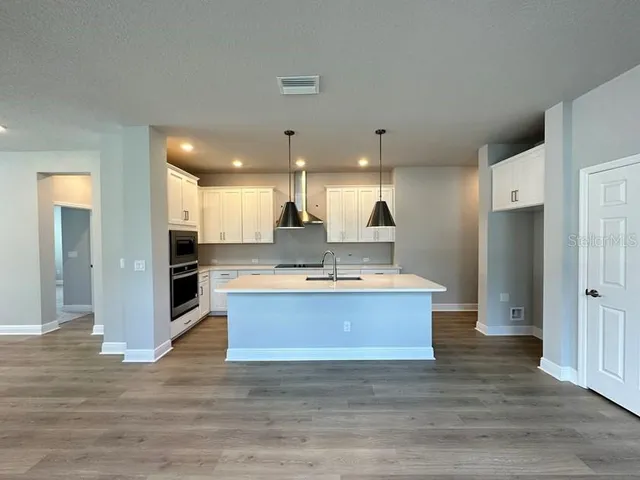 a view of kitchen with kitchen island a sink stainless steel appliances and cabinets