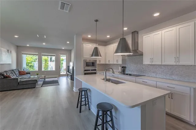 a kitchen with a table chairs refrigerator and microwave