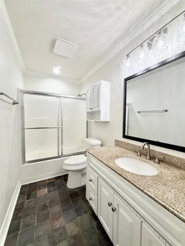 a bathroom with a granite countertop sink toilet and mirror