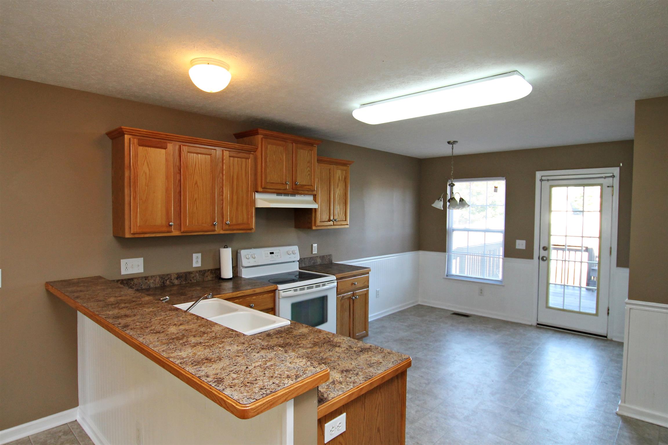 135 Filly Lane Springfield, TN 37172 - Photo 5 of 15 a kitchen with granite countertop a stove a sink dishwasher and a microwave oven with white cabinets
