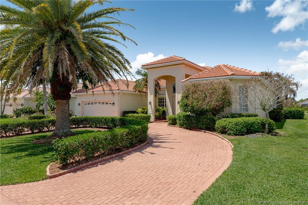 2216 Southeast Stonehaven Road Port St. Lucie, FL 34952 - Photo 58 of 67 a front view of a house with a yard and potted plants