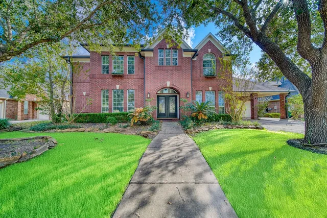 a front view of a house with yard and green space