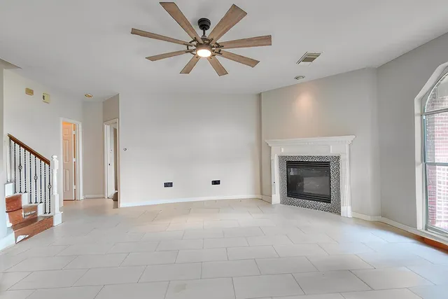 an empty room with fireplace and fan