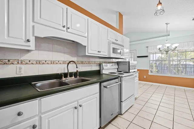 a kitchen with kitchen island granite countertop a sink stainless steel appliances and cabinets
