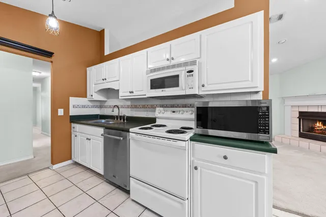 a kitchen with stainless steel appliances granite countertop white cabinets a sink and dishwasher