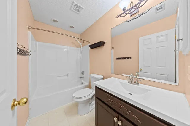 a spacious bedroom with a bed and a chandelier