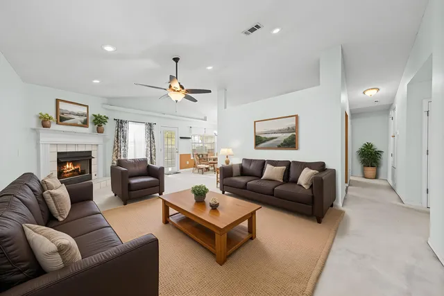 a living room with furniture ceiling fan and a fireplace