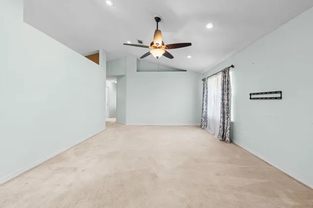 en empty room with ceiling fan and window