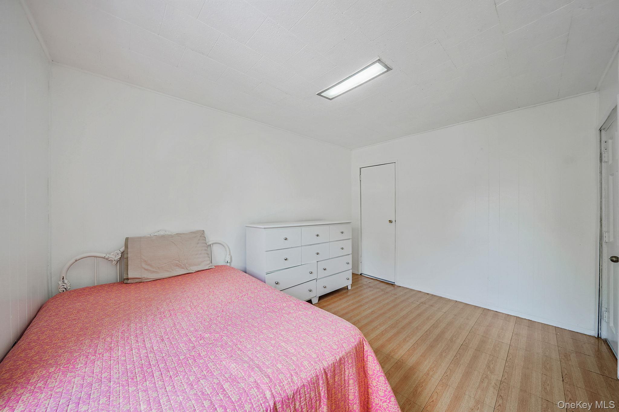 91-26 110th Street Queens, NY 11418 - Photo 12 of 25 a bedroom with a bed and wooden floor