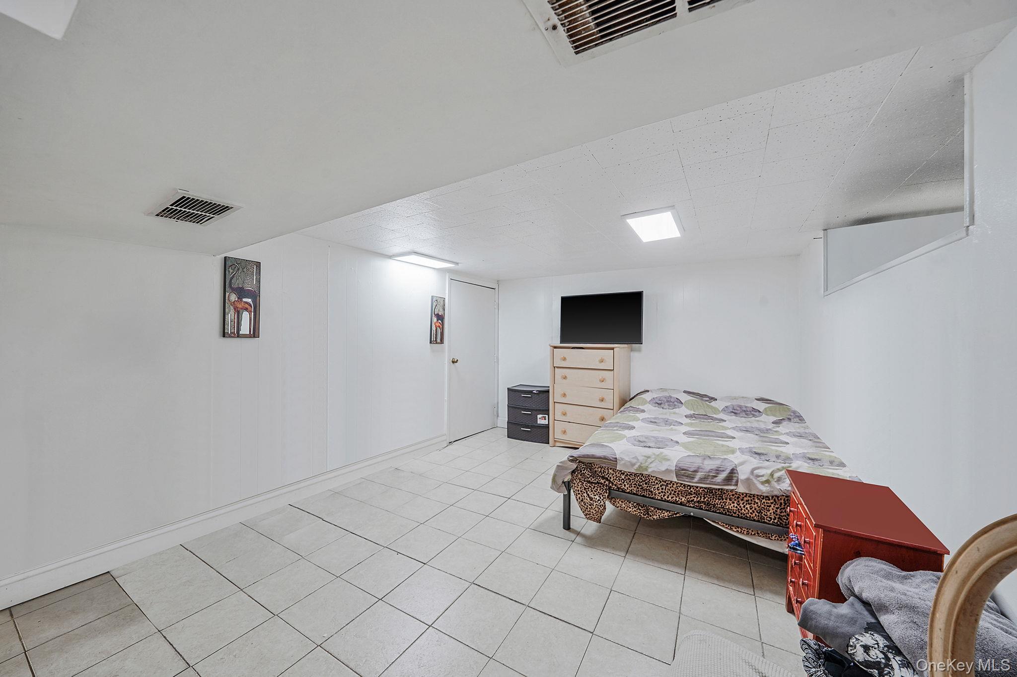 91-26 110th Street Queens, NY 11418 - Photo 19 of 25 a bedroom with a bed and a couch