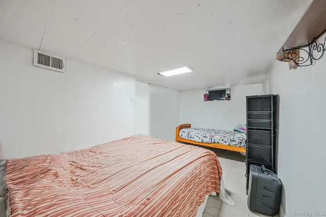 a bedroom with a bed and a refrigerator