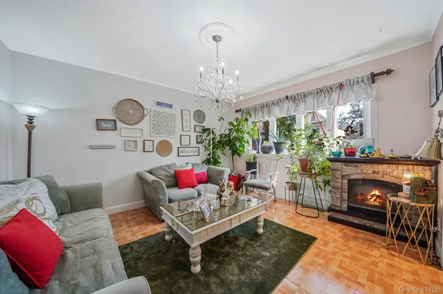 a living room with furniture a fireplace and a chandelier