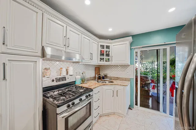 a kitchen with stainless steel appliances granite countertop a stove and a refrigerator