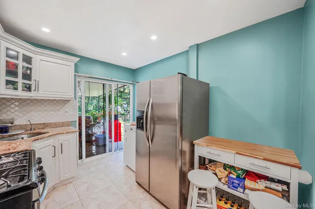 a kitchen with stainless steel appliances granite countertop a refrigerator and a stove top oven