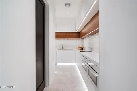 a kitchen with stainless steel appliances a sink a stove a refrigerator and cabinets