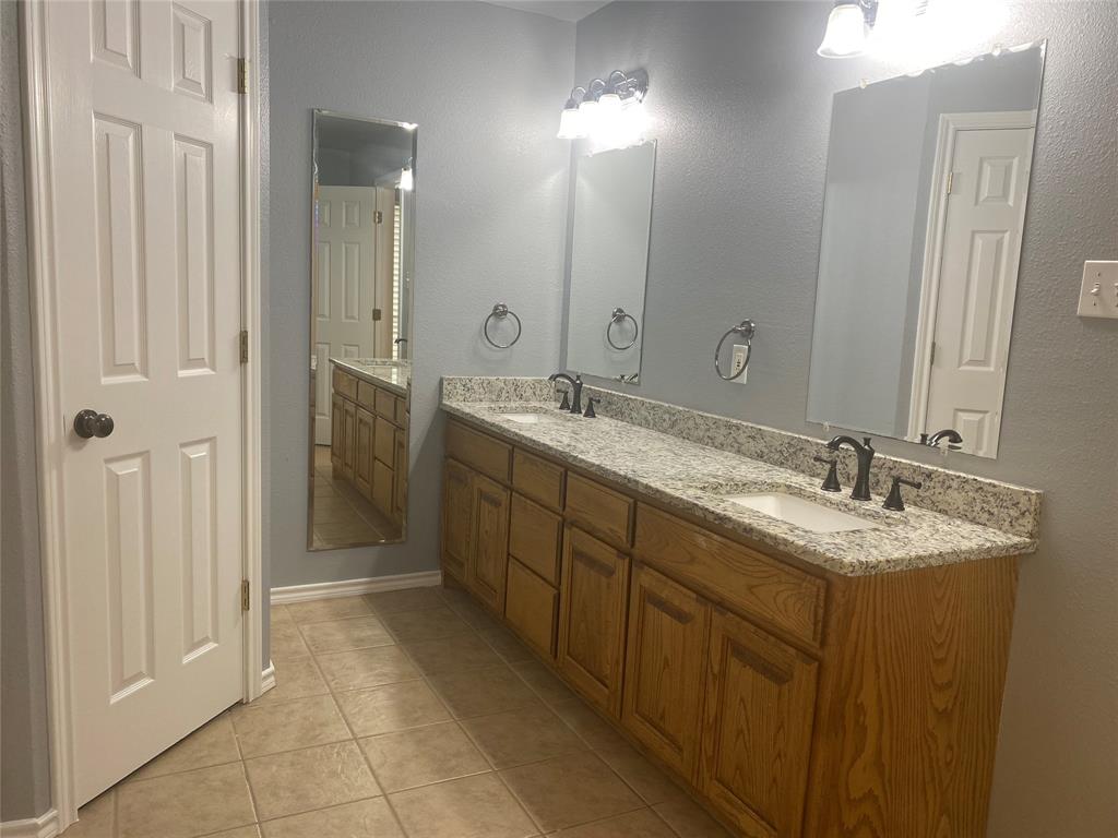 150 Hunters Circle Weatherford, TX 76088 - Photo 21 of 25 a spacious bathroom with a granite countertop sink a mirror and a