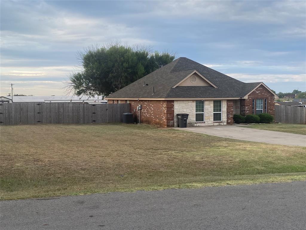 150 Hunters Circle Weatherford, TX 76088 - Photo 3 of 25 a front view of a house with a garden