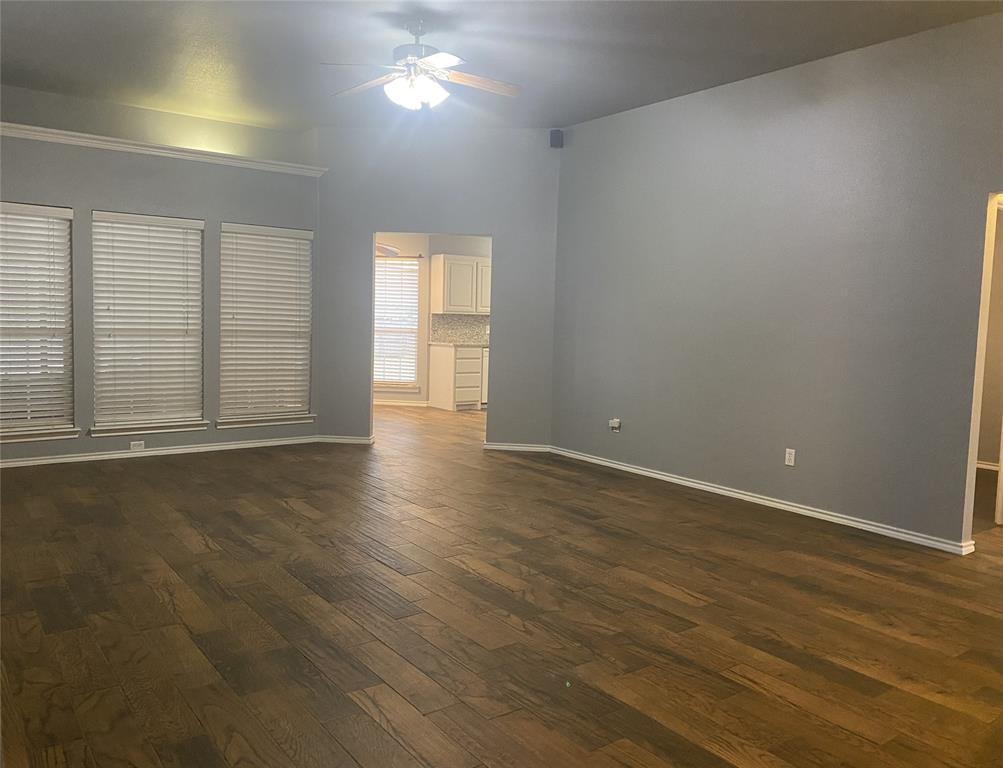 150 Hunters Circle Weatherford, TX 76088 - Photo 4 of 25 an empty room with wooden floor and windows