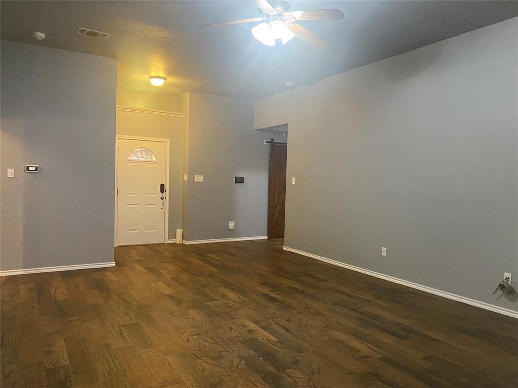 150 Hunters Circle Weatherford, TX 76088 - Photo 5 of 25 an empty room with wooden floor and windows