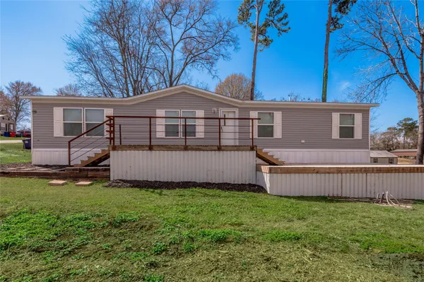 a view of a house with backyard and wooden