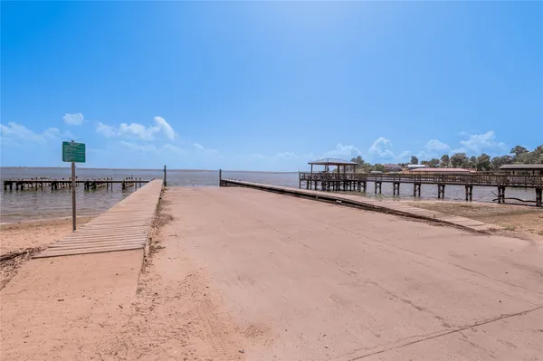 a view of a patio with a table and chairs under an umbrella with a barbeque