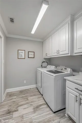 a view of a storage utility room with cabinets washer and dryer