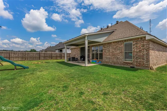 a view of a house with backyard and porch