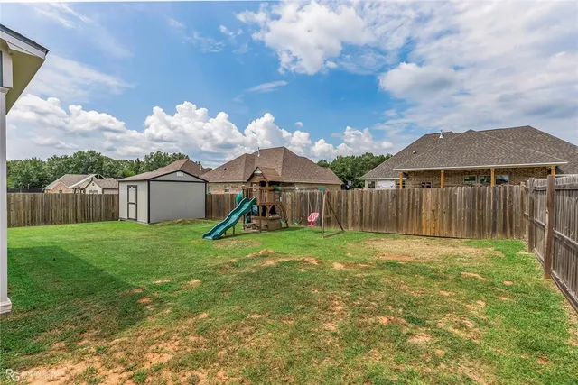 a view of a house with backyard and a slide