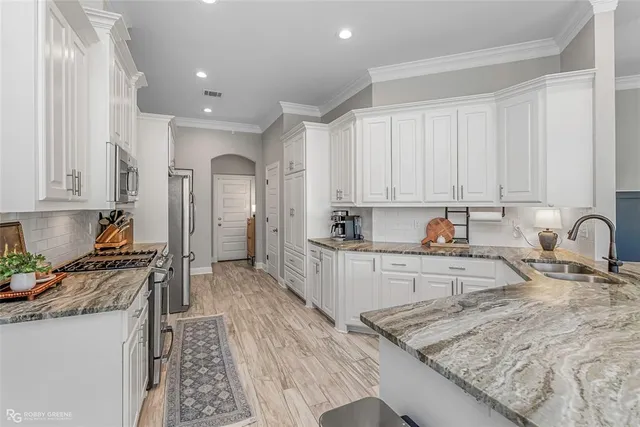 a kitchen with stainless steel appliances granite countertop a sink stove and refrigerator
