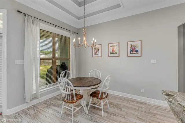 a dining room with furniture a chandelier and wooden floor