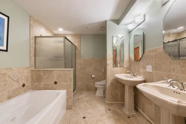 a bathroom with a double vanity sink mirror and bathtub