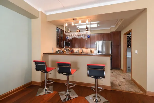 a dining room with wooden floor and chandelier