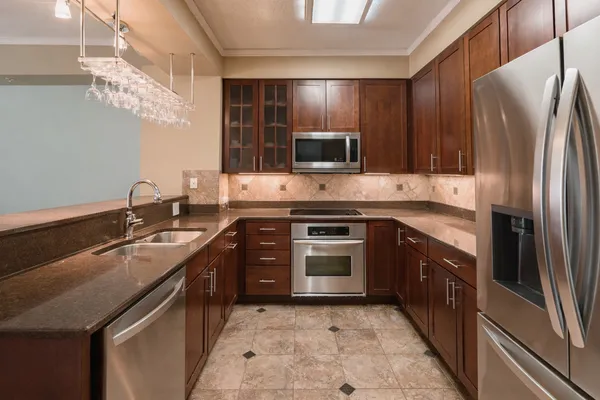 a kitchen with kitchen island granite countertop a sink stove and refrigerator