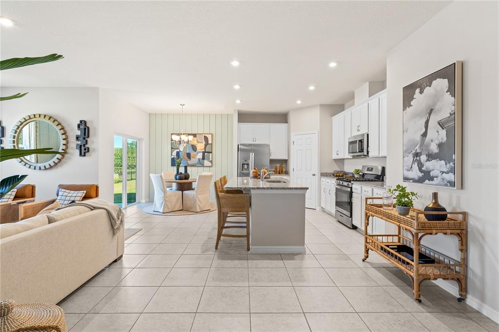 9616 Starling Loop Leesburg, FL 34788 - Photo 3 of 31 a living room with furniture a dining table and kitchen view