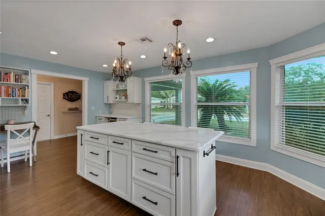 a kitchen with kitchen island white cabinets and refrigerator