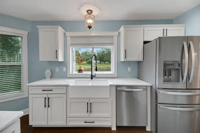 a kitchen with stainless steel appliances a refrigerator sink and cabinets