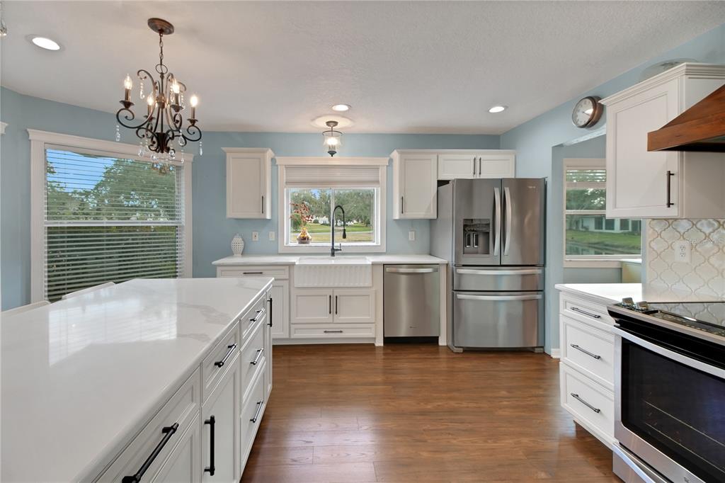32801 Oak Park Drive Leesburg, FL 34748 - Photo 14 of 46 a kitchen with stainless steel appliances a refrigerator sink and cabinets