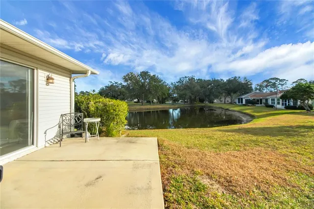 a front view of a house with a garden and lake view