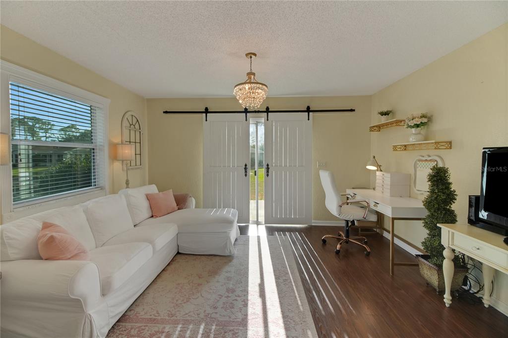 32801 Oak Park Drive Leesburg, FL 34748 - Photo 25 of 46 a living room with furniture a fireplace and a chandelier