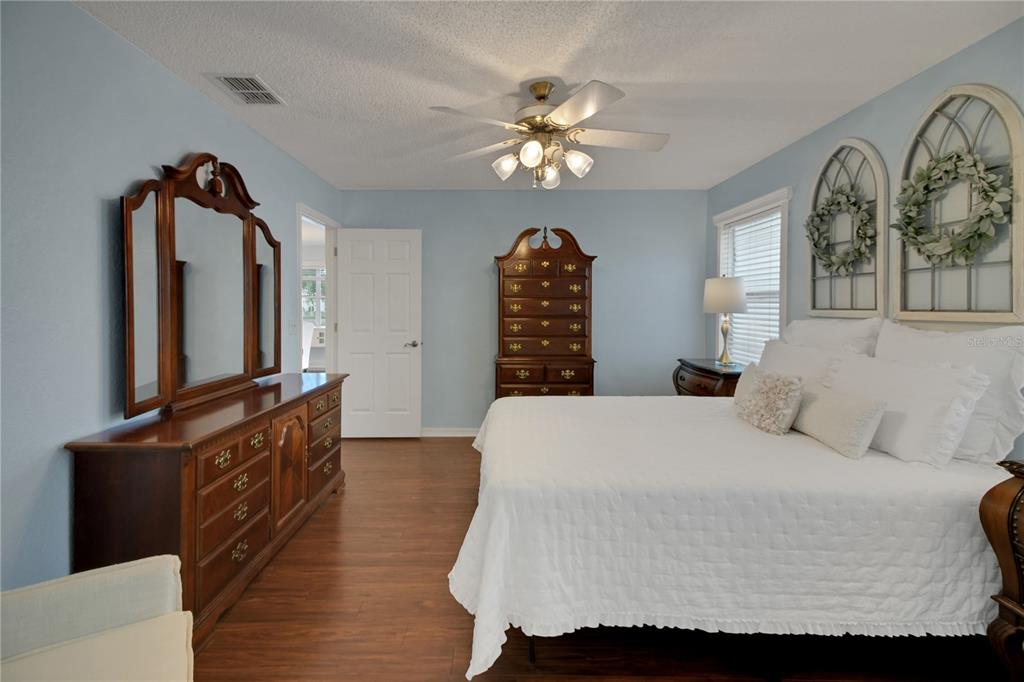 32801 Oak Park Drive Leesburg, FL 34748 - Photo 31 of 46 a bedroom with a bed and dresser with mirror