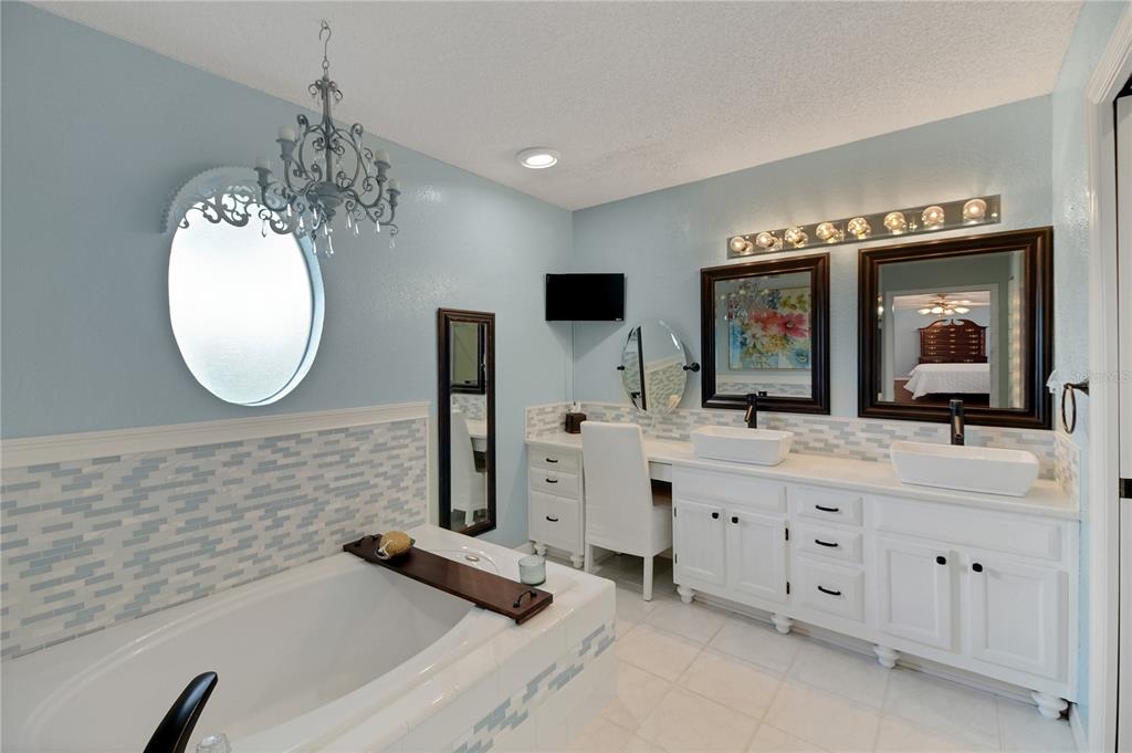 32801 Oak Park Drive Leesburg, FL 34748 - Photo 33 of 46 a bathroom with a double vanity sink mirror and bathtub